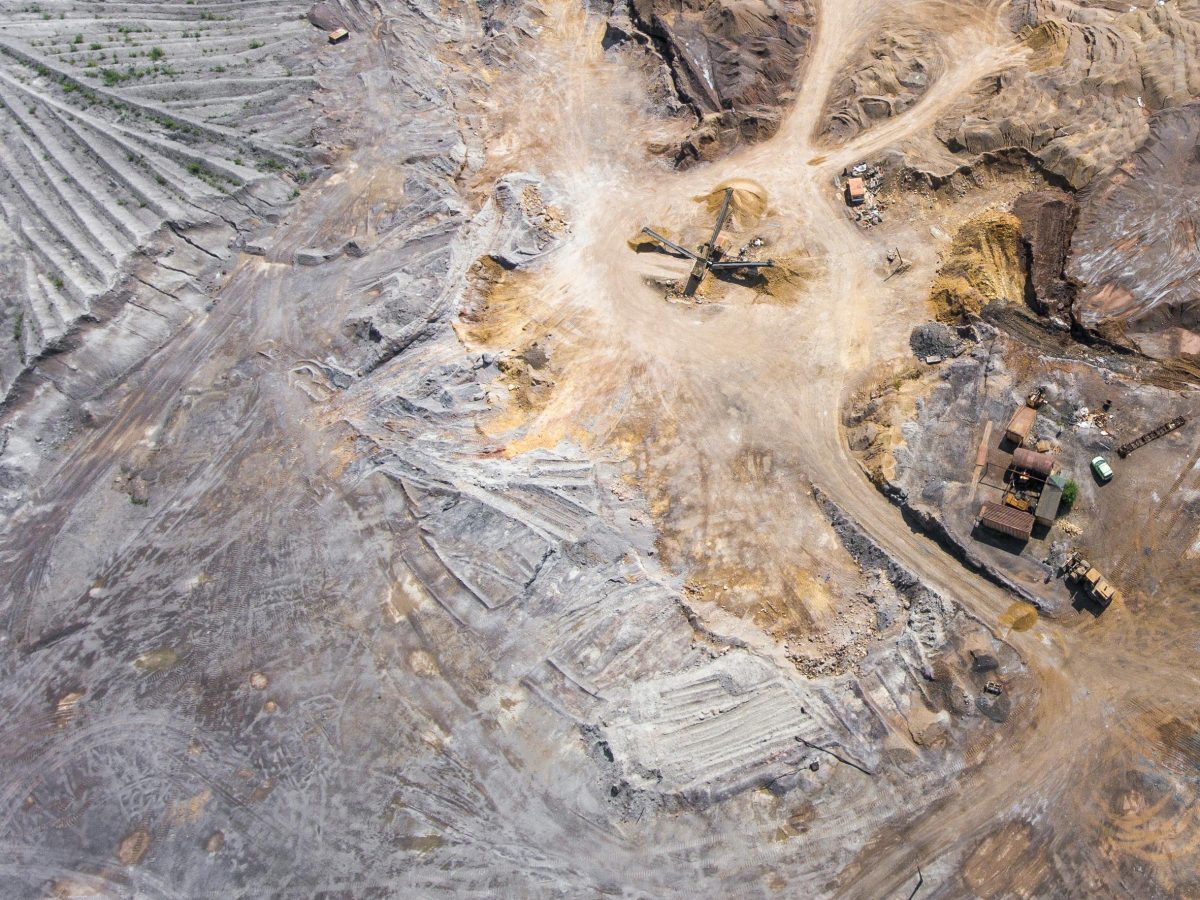 An expansive aerial view of a mining site displaying machinery and earth patterns.